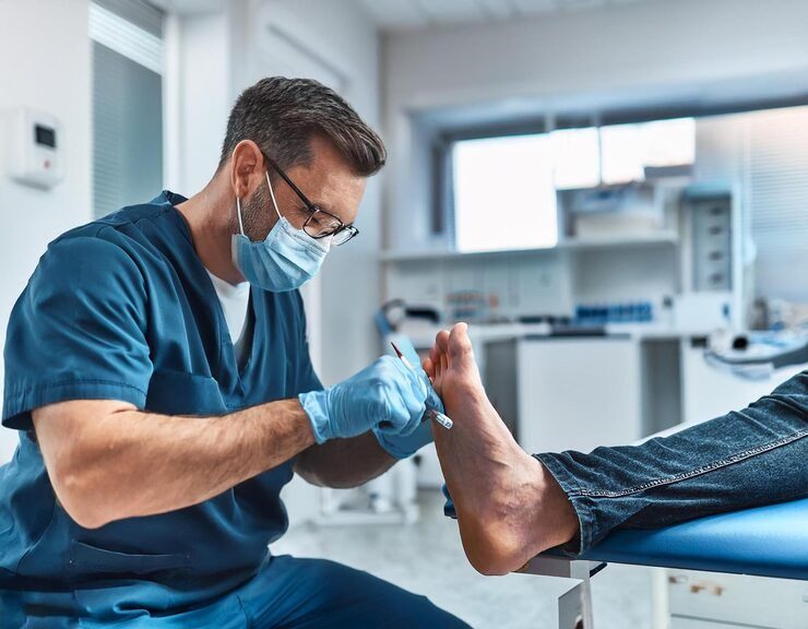 Clinician performing a neuropathy evaluation on a patient's foot
